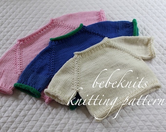 May include: Three knitted baby sweaters in pink, blue, and white with green trim around the neck and sleeves. The sweaters are stacked on top of each other and the text "bebeknits knitting pattern" is visible at the bottom of the image.