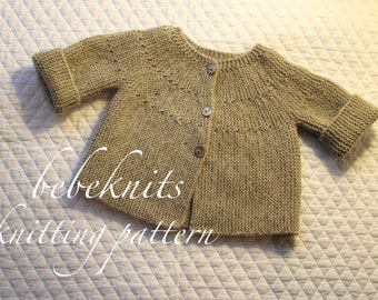 May include: A beige knitted baby cardigan with three brown buttons. The sleeves have folded cuffs. The text "bebeknits knitting pattern" is written in cursive on the lower left side of the image.