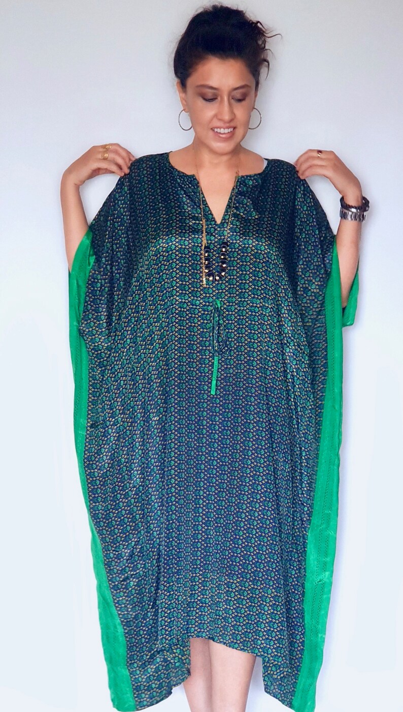 May include: A green and blue patterned kaftan with a green trim. The kaftan has a V-neck and a drawstring waist.