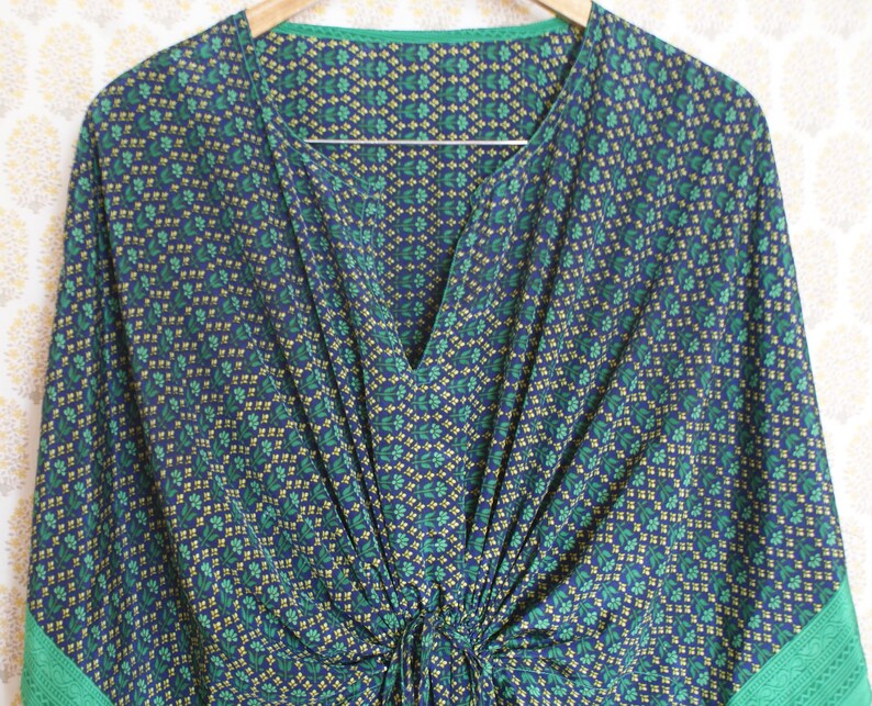 May include: A blue and green patterned kaftan with a V-neck and a gathered waist.
