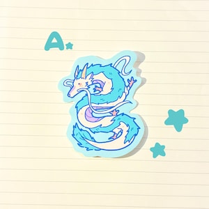 May include: A sticker featuring a stylized, light blue dragon with white and lavender accents. The dragon is surrounded by a light blue outline. The letter "A" and two star shapes are also in the image.