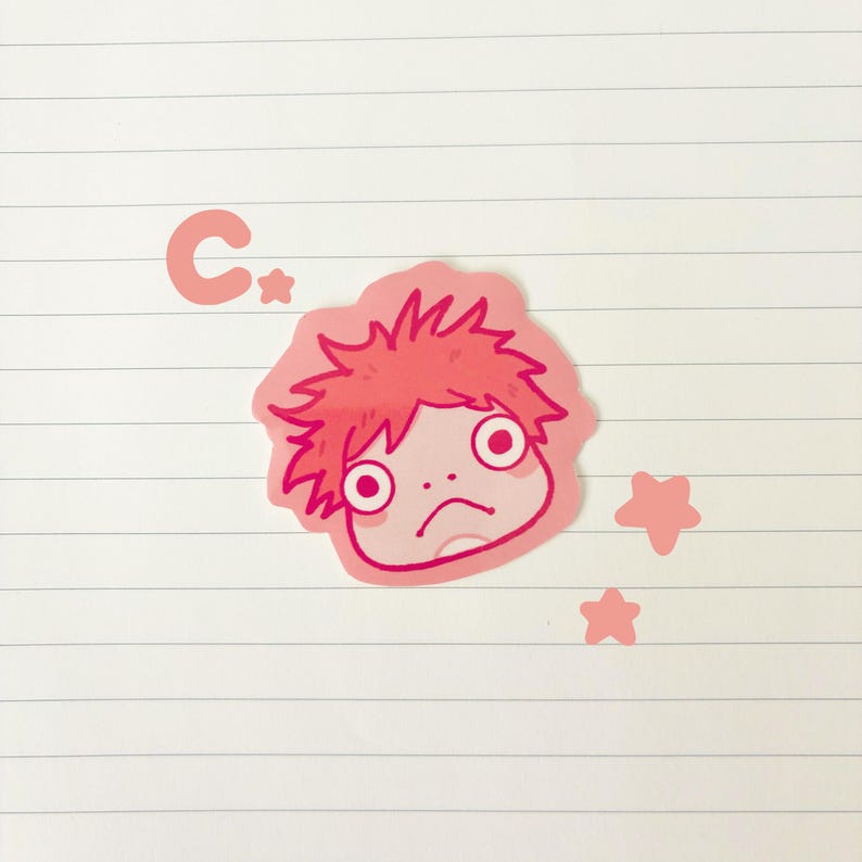 May include: A pink sticker featuring a cartoon character with red hair and a sad expression. The sticker is surrounded by a pink outline and includes the letter "C" and three pink stars. The sticker is on a white lined paper background.