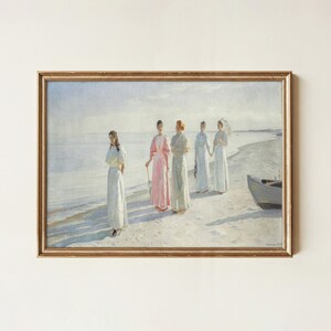 Może przedstawiać: Oprawiony obraz przedstawia sześć postaci w długich sukniach na plaży. Postacie są w odcieniach bieli i różu. Mała łódź stoi na piasku w pobliżu wody. Niebo jest bladoniebieskie.