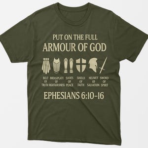 Könnte beinhalten: Olivgrünes T-Shirt mit dem Text "PUT ON THE FULL ARMOUR OF GOD" und Illustrationen von Rüstungsteilen. Darunter stehen die Worte "BELT OF TRUTH", "BREASIPLATE OF RIGHTEOUSNESS", "SHOES OF PEACE", "SHIELD OF FAITH", "HELMET OF SALVATION" und "SWORD OF SPIRIT".