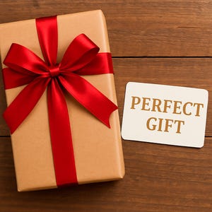 May include: A rectangular gift box wrapped in plain brown paper with a large, vibrant red satin ribbon tied in a bow. Next to the gift is a white rectangular card with rounded corners featuring the text PERFECT GIFT printed in gold lettering.