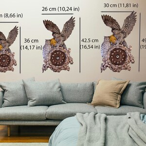 May include: Three wall clocks featuring a brown owl design with spread wings, perched on a textured base. The clocks are shown in three sizes: 22 x 36 cm, 26 x 42.5 cm, and 30 x 49.5 cm, with clear dimension labels provided for each individual clock.