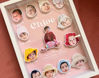 May include: A framed baby photo display with a white frame and a pink background. The display features multiple baby photos labeled with months, the name "Chloé", and the text "PREMIÈRE ANNÉE 26 OCTOBRE 2024".