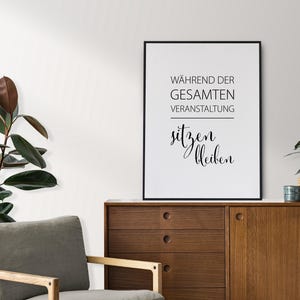 Puede incluir: Un cuadro rectangular con marco negro que presenta un fondo blanco con el texto en negro WÄHREND DER GESAMTEN VERANSTALTUNG sitzen bleiben. La impresión se muestra en orientación vertical, exhibiendo una combinación de tipografía sans-serif y caligráfica.