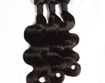 May include: Three bundles of wavy, dark brown human hair extensions. Each bundle is tightly wrapped at the top with black thread. The hair has a natural shine and a soft, flowing texture, perfect for creating voluminous hairstyles.