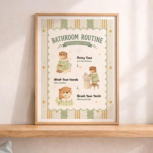 May include: A framed print with a bathroom routine for children. The print features illustrations of an otter performing daily tasks: potty time, washing hands, and brushing teeth. The text includes "Bathroom Routine" and "Little Daily Steps."