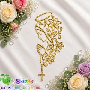 Op de afbeelding: Een gouden machinaal borduurontwerp met het profiel van een figuur met een halo, biddende handen, een rozenkrans met een kruis en leliebloemen. Het ontwerp staat op een witte stoffen achtergrond omringd door roze, witte en paarse rozen.
