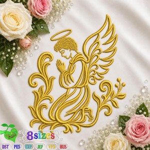 Puede incluir: Un diseño de bordado a máquina en color dorado de un ángel arrodillado con alas y halo, rodeado de remolinos decorativos. El diseño está centrado sobre una tela blanca, acentuado por rosas rosas y blancas y pequeñas flores blancas.