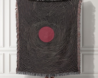 Manta tejida minimalista con motivo solar abstracto, tapiz moderno con líneas topográficas, arte mural contemporáneo