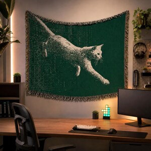 May include: A rectangular woven wall tapestry featuring a dark green background with a white graphic illustration of a cat in a leaping pose. The design includes a subtle grid pattern and the edges are finished with a decorative fringed border.