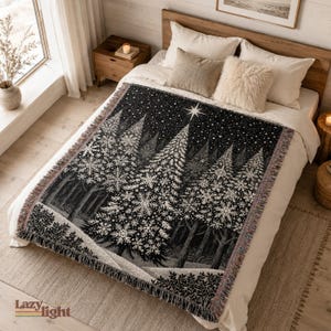 Könnte beinhalten: Eine schwarz-weiße Webdecke mit einer Waldszene, einem großen zentralen Tannenbaum mit Schneeflockenmustern, einem hellen Stern an der Spitze und einem Sternenhimmel. Die Decke hat einen gefransten Rand und eine strukturierte Oberfläche.