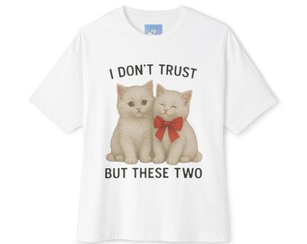 Könnte beinhalten: Weißes T-Shirt mit einer Illustration von zwei Kätzchen und dem Text "I DON'T TRUST BUT THESE TWO". Ein Kätzchen trägt eine rote Schleife. Das T-Shirt hat einen Rundhalsausschnitt und kurze Ärmel.