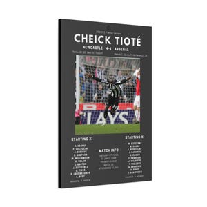 May include: A framed poster featuring a soccer match between Newcastle and Arsenal, with the score 4-4. The poster includes the names of the players, match details, and a photo of Cheick Tioté celebrating a goal. The background is dark gray.