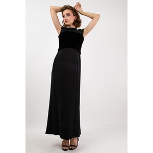 May include: A black sleeveless maxi dress with a velvet bodice. The dress has a simple, elegant design and is perfect for a formal occasion.