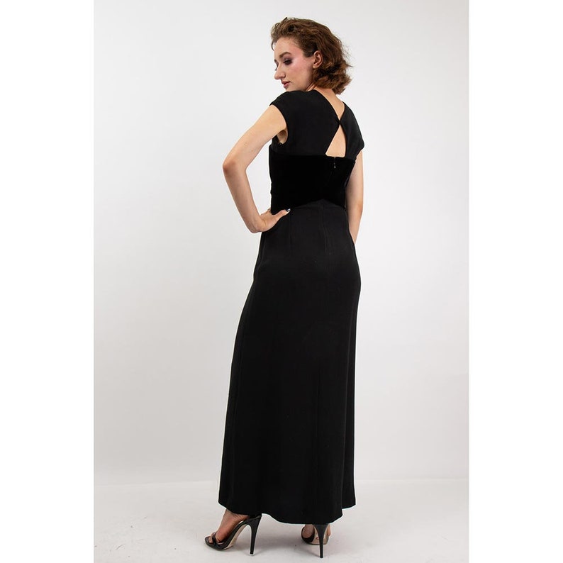 May include: A black maxi dress with a velvet bodice and a keyhole back detail. The dress has a fitted bodice and a flowing skirt.