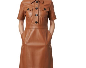 May include: A short-sleeved, brown leather dress with a collared neckline and button-down front. The dress features two chest pockets with button closures, a fitted waist, and two side pockets. The dress is knee-length.