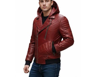 Puede incluir: Chaqueta de cuero burdeos con capucha y cremallera diagonal. Detalles acolchados en los hombros, dobladillo de canalé negro y puños negros. El modelo lleva vaqueros azules. Prenda de abrigo elegante.