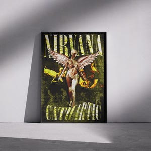 May include: Framed poster featuring the word "NIRVANA" at the top, with the word "IN UTERO" at the bottom. The artwork depicts a nude angel with wings, and other figures in a dark green and yellow color scheme.