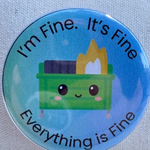 May include: Round button with a blue and green gradient background. The button features a cartoon green dumpster on fire with the text "I'm Fine. It's Fine. Everything is Fine" in a circular layout.
