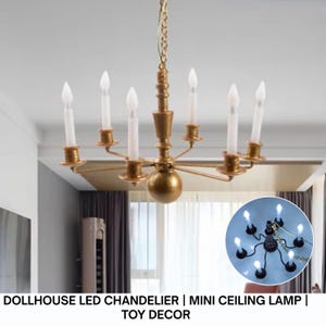 May include: A miniature gold-colored chandelier with six white candle-shaped LED lights. The chandelier is suspended from a gold chain and features a central sphere. Text at the bottom reads: DOLLHOUSE LED CHANDELIER | MINI CEILING LAMP | TOY DECOR.