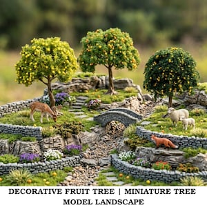 Può includere: Paesaggio modello in miniatura con tre alberi da frutto con frutti gialli e arancioni. Un ponte di pietra attraversa un piccolo ruscello, con figurine di cervo, pecora e volpe. La scena è circondata da muri di pietra e vegetazione.