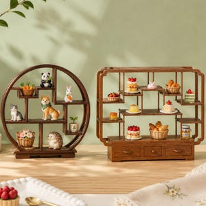 May include: Two wooden display shelves, one circular and one rectangular with three drawers, holding miniature figurines of animals including a panda, rabbit, cat, and hedgehog, alongside tiny food items like cakes, pastries, and a honey jar.
