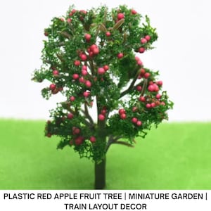 Può includere: Un albero in miniatura di plastica con tronco marrone, foglie verdi e mele rosse. L'albero è progettato per giardini in miniatura e plastici ferroviari. Il testo in basso recita: PLASTIC RED APPLE FRUIT TREE | MINIATURE GARDEN | TRAIN LAYOUT DECOR.