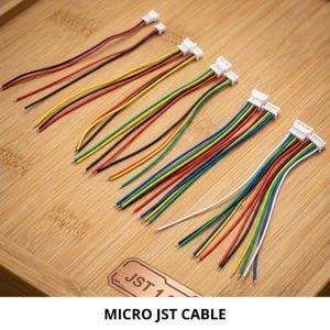 以下が含まれることがあります： 白いプラスチックコネクタとマルチカラーの絶縁ワイヤーを備えたマイクロJSTケーブルのコレクション。このセットには、赤、黒、黄、緑、青、白のワイヤーが露出した金属チップで構成された、ワイヤー数の異なるケーブルが含まれています。