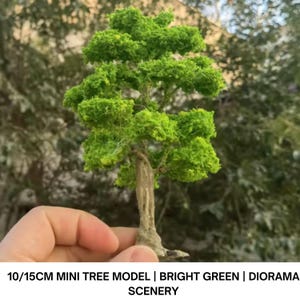 Puede incluir: Un modelo de árbol en miniatura con follaje verde brillante y un tronco marrón texturizado. El árbol mide aproximadamente 10 a 15 cm de altura. El texto en la parte inferior dice "10/15CM MINI TREE MODEL | BRIGHT GREEN | DIORAMA SCENERY".
