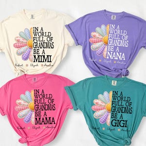 May include: Four t-shirts in cream, purple, pink, and teal. Each shirt features a daisy design with the text "In a world full of grandmas be a Mimi, Nana, Mama, Gigi" and names below. The daisy petals are patchwork.