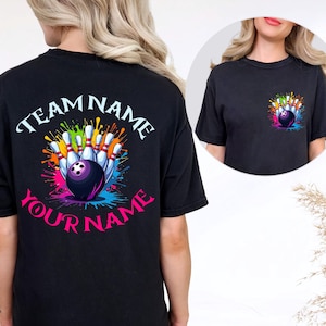May include: Black t-shirt featuring a bowling design. The design includes bowling pins, a bowling ball, and colorful paint splatters. The text "TEAM NAME" and "YOUR NAME" are arched above and below the bowling graphic. A smaller version of the design is on the front.