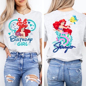 May include: A light gray t-shirt featuring a front graphic of Ariel from The Little Mermaid with the text "Birthday Girl". The back of the shirt shows Ariel, the number 5, and the name "Sawyer".