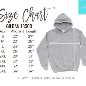 Op de afbeelding: Een lichtgrijs, zwaar gemengd sweatshirt met capuchon en een maattabel. De maattabel toont de breedte- en lengtematen in centimeters voor de maten S t/m 5XL. De sweatshirt heeft een capuchon en is gelabeld GILDAN 18500.