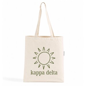 Op de afbeelding: Een natuurkleurige canvas draagtas met een donker olijfgroene afbeelding van een zon met stralen, gecentreerd boven de tekst "kappa delta" in een eenvoudig, kleingeschreven schreefloos lettertype. De tas heeft twee lange schouderbanden.