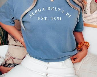 Camiseta Alpha Delta Pi branca licenciada, fundada em 1851, nas cores da irmandade. Presente ideal para a Semana de Recepção de Irmandades. Presente para irmãs mais velhas/afilhadas. Ideia de presente para a Semana de Recepção. Camiseta ADPi.