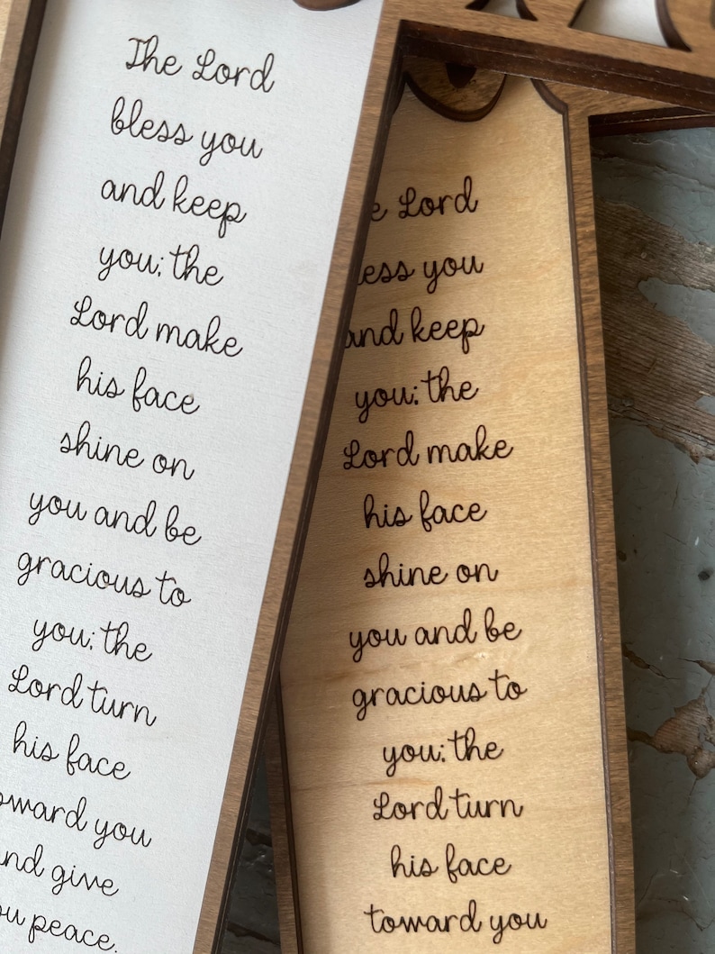 Peut inclure: Une pancarte en bois avec le texte "The Lord bless you and keep you: the Lord make his face shine on you and be gracious to you: the Lord turn his face toward you and give you peace." La pancarte est de couleur brun clair et a un cadre brun fonc&eacute;.