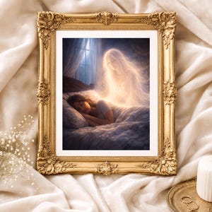 May include: A framed art print featuring a sleeping person in bed with a glowing ethereal figure above. The artwork is set within an ornate gold frame. The image is on a cream-colored fabric background.