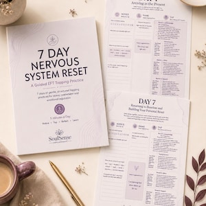 Könnte beinhalten: Ein 7 Day Nervous System Reset Arbeitsbuch für geführte EFT-Klopftechniken mit weißem Einband, violettem Text und SoulSense-Logo, dazu zwei ausgedruckte Übungsblätter für Tag 1 und Tag 7, ein goldener Stift und eine Keramiktasse.