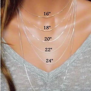May include: A display of silver necklaces of varying lengths, including 16", 18", 20", 22", 24", and 30" options. The necklaces are shown against a neutral background, highlighting the different chain styles and lengths available.