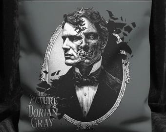 Op de afbeelding: Grijze draagtas met een zwart-wit illustratie van een mannenportret in een ovale lijst. Het gezicht van de man is gedeeltelijk aan het vervallen. De tekst "THE PICTURE OF DORIAN GRAY" staat eronder.