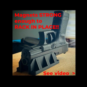 Puede incluir: Una pistola negra apoyada en un soporte negro. El texto rojo dice "Magnets STRONG enough to RACK IN PLACE!!" y "See video >". La imagen muestra un arma de fuego y su estructura de soporte.
