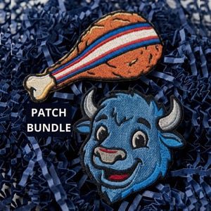May include: Two embroidered patches featuring a brown fried chicken leg with a red, white, and blue stripe and a blue buffalo head with grey horns. The text PATCH BUNDLE is visible in a black box. The patches are placed on dark blue shredded paper.