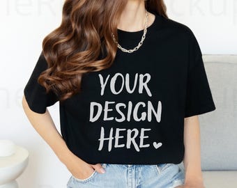 May include: Black t-shirt with the text "YOUR DESIGN HERE" in white. The model is wearing denim shorts and a silver chain necklace. The t-shirt is a classic crew neck style.