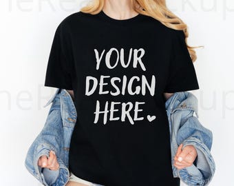 May include: Black t-shirt with the text "YOUR DESIGN HERE" in white, paired with a light blue denim jacket. The shirt is a classic crew neck style, and the overall look is casual and modern.