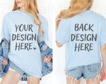 May include: Light blue t-shirt with the text "YOUR DESIGN HERE" on the front and "BACK DESIGN HERE" on the back. The model is wearing a denim jacket and denim shorts. The t-shirt is a mock-up for custom designs.