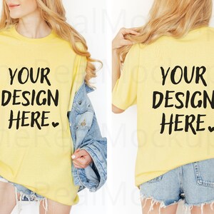 Könnte beinhalten: Gelbes T-Shirt mit dem Text "YOUR DESIGN HERE" in Schwarz. Das Model trägt eine hellblaue Jeansjacke und Jeansshorts. Das T-Shirt ist ein Mock-up für individuelle Designs.